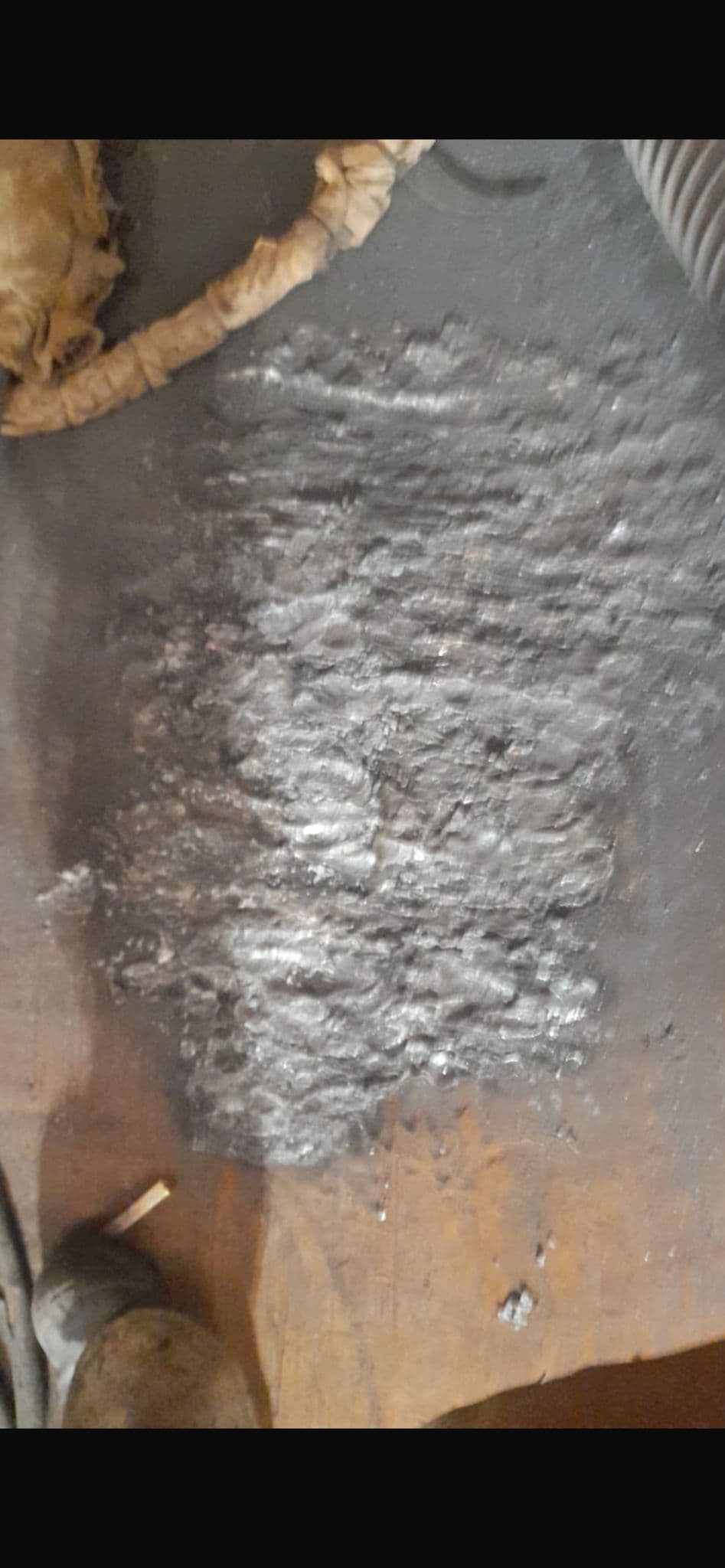 Slag residue and arc gouging marks on industrial steel
