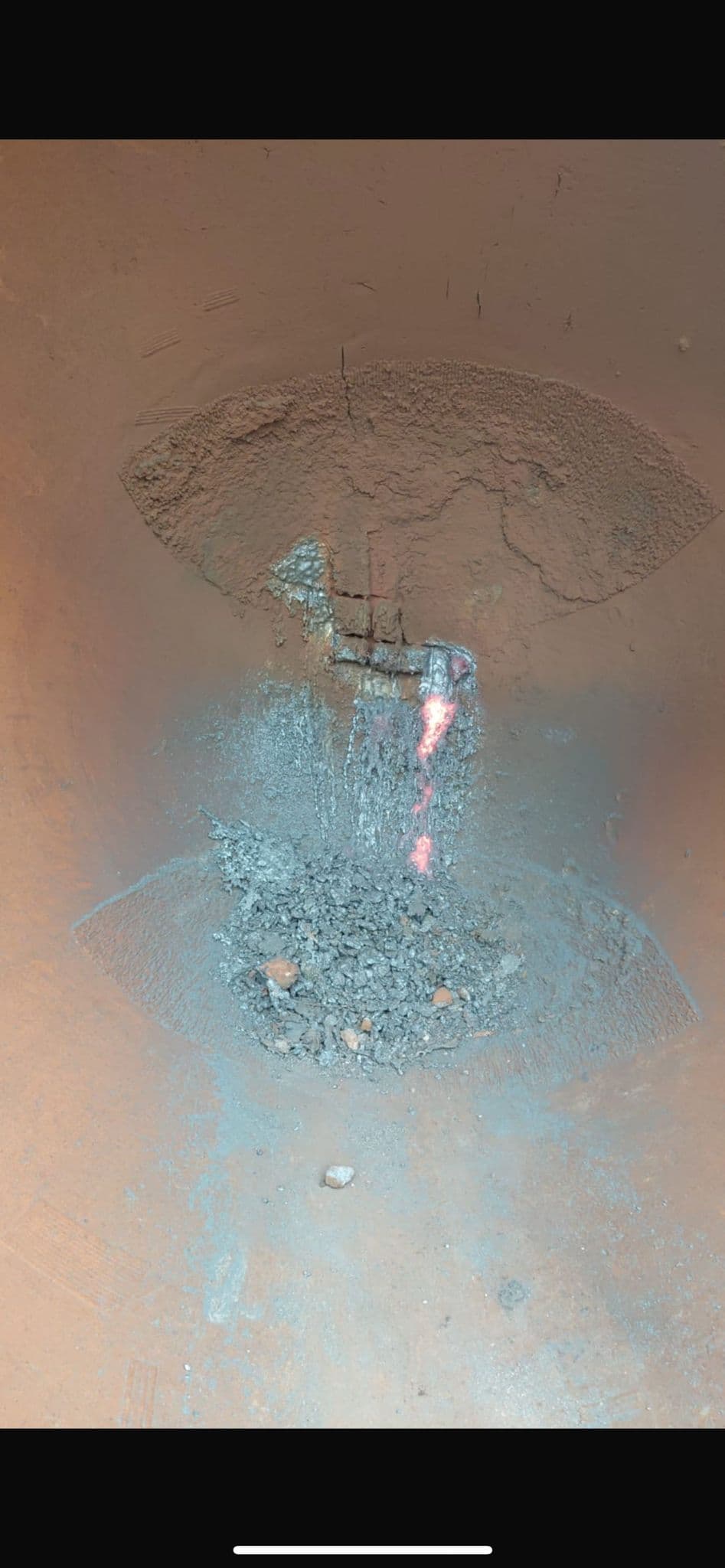 Slag pot during active removal process with hot debris